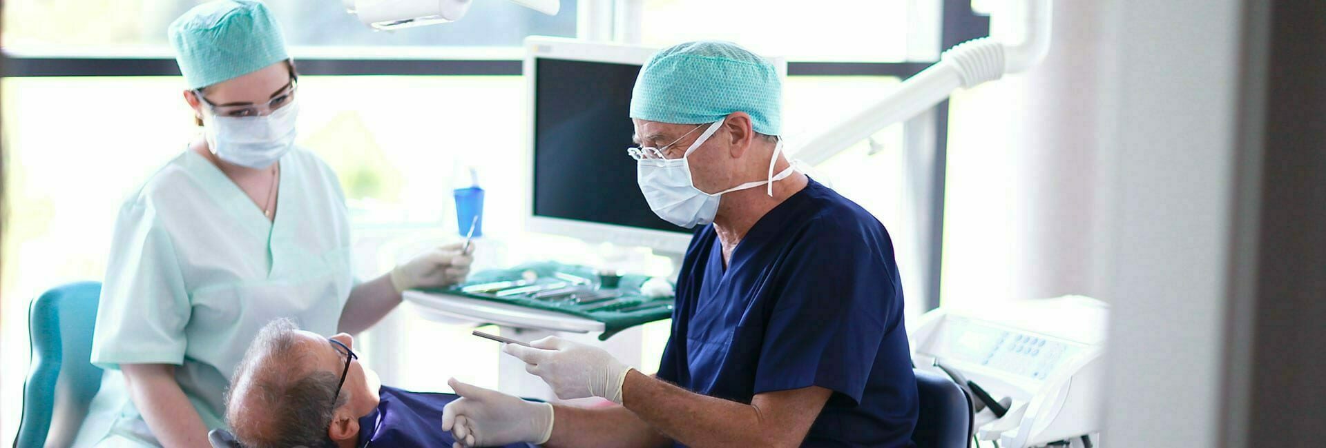 Zahnarzt und Zahnarzthelferin während einer Behandlung