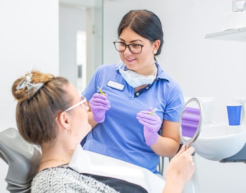 Prophylaxehelferin, Dentalhygienikerin beim Erklären der Zahnpflege Methoden
